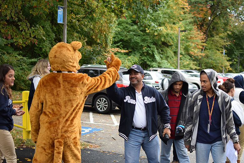 a person high fiving the Nittany Lion