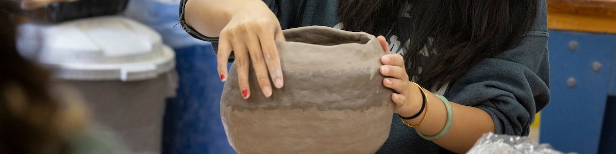 student working on her ceramic pot