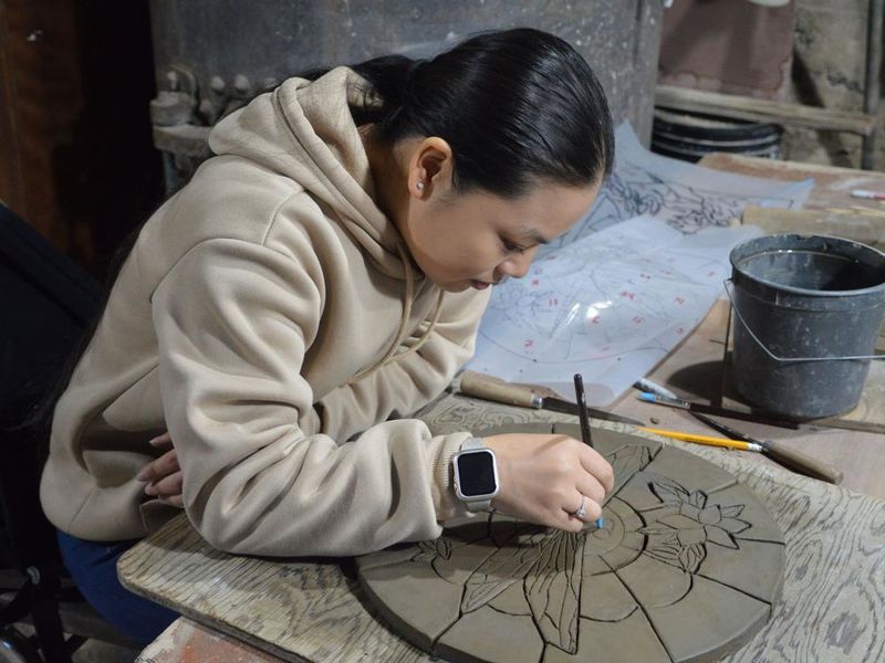 Student creating a ceramic tile