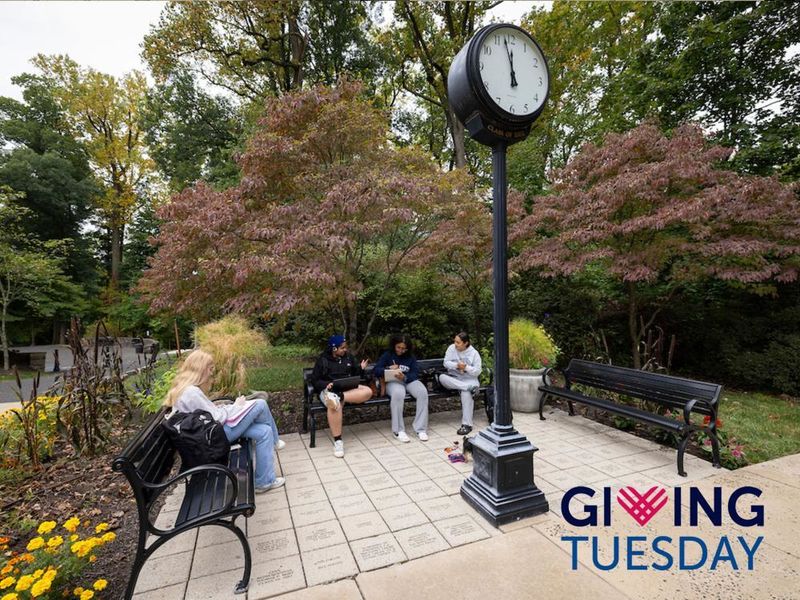 Students sitting on benches around a vintage clock