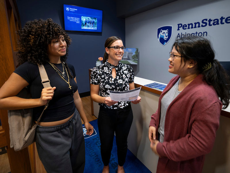 two students talking with financial aid staff 