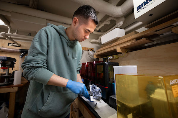 student holding molded object at MakerSpace 