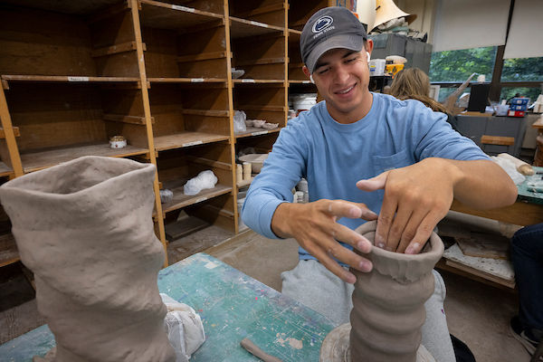 student working on ceramics vase 