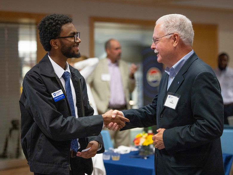 Student shaking hand with a person