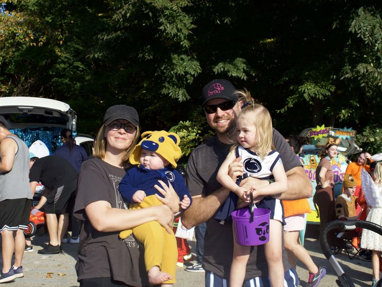 Parents holding their children for a photo at Trunk or Treat