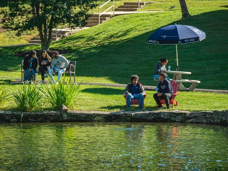 students sitting in front of Lares pond