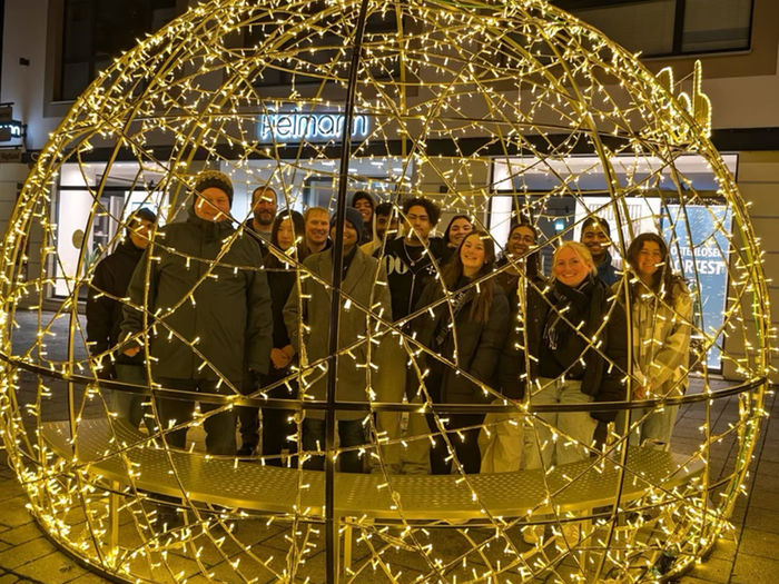 students with holiday lights all smiling