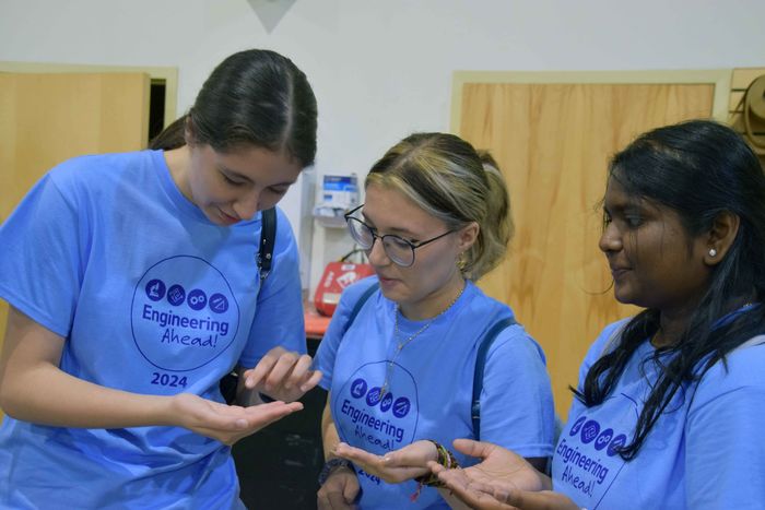 three women students looking at air particle