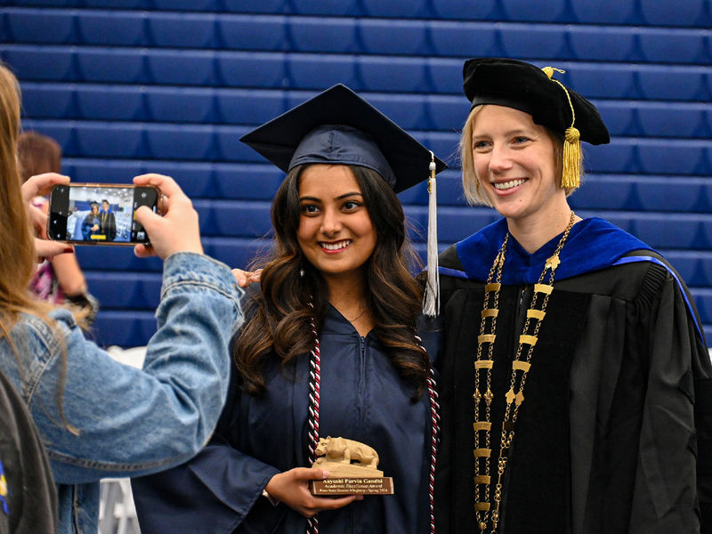 graduate and chancellor smiling for a photo