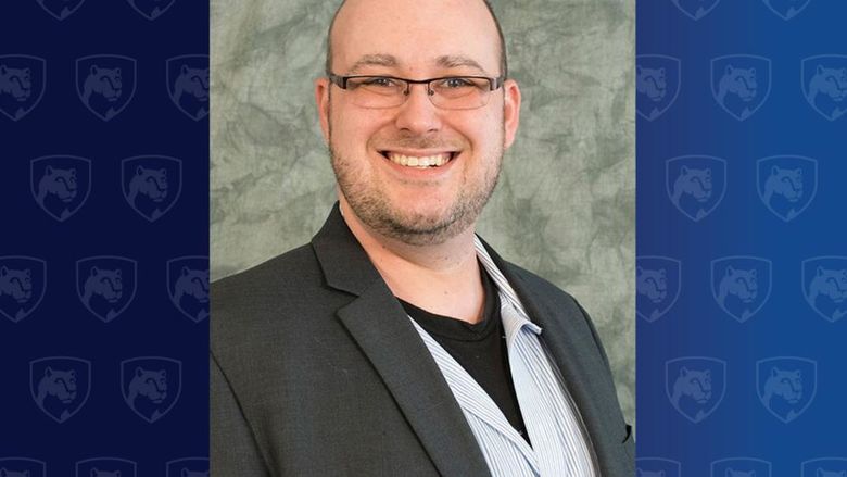 Head shot of a man with glasses in a dark jacket