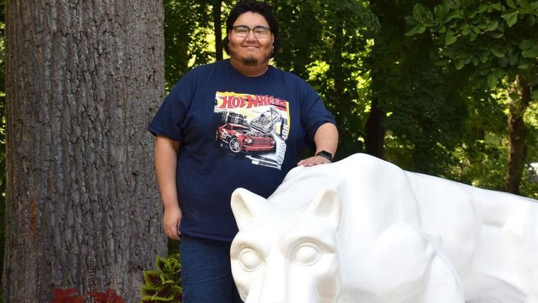 Man standing behind lion statue