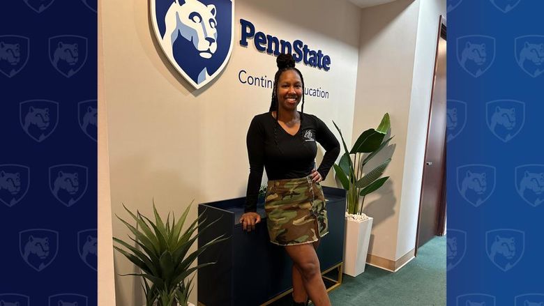 Woman standing in front of Penn State sign