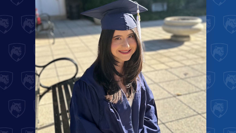 Student in cap and gown sitting outside