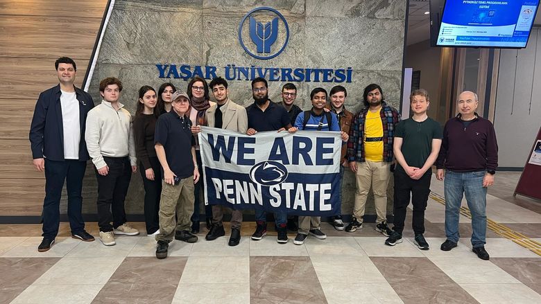 Group photo of students with the Penn State "WE ARE" flag