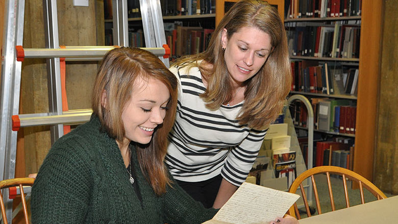 student with museum worker looking at documents