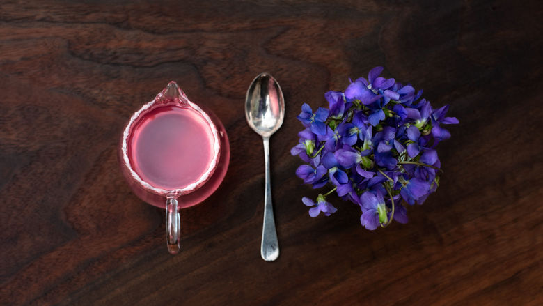 measuring cup, spoon, and flowers on a table 