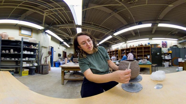 Panoramic view of student sculpting in an art studio