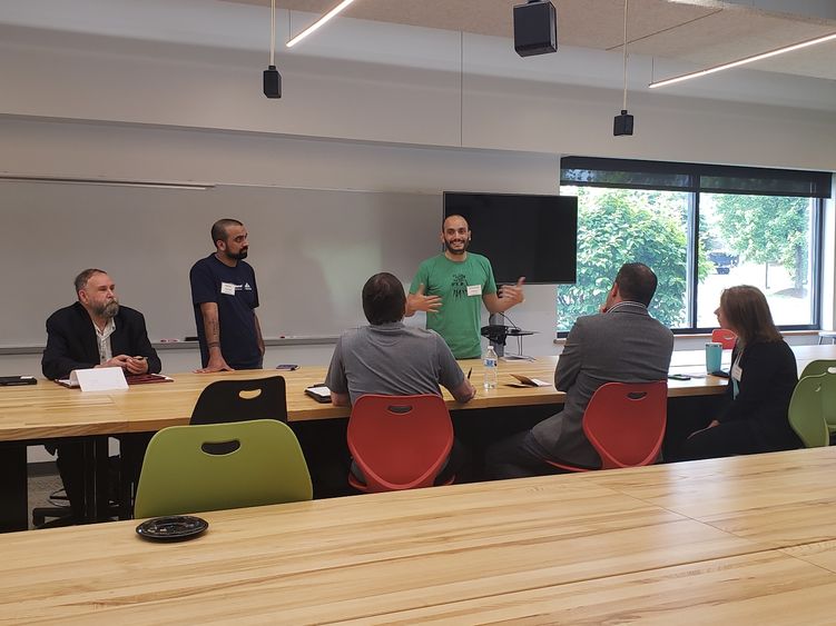 People sitting and standing around a table while talking